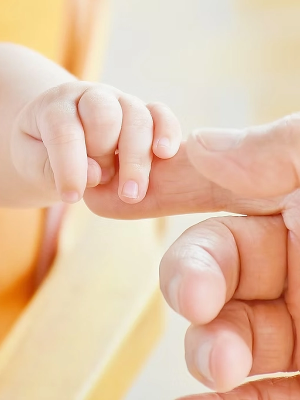 Main de bébé tenant un doigt